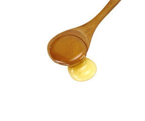 Honey in a wooden spoon isolated on white background.