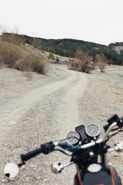 motorcycle located on narrow countryside road in dry field during trip in nature