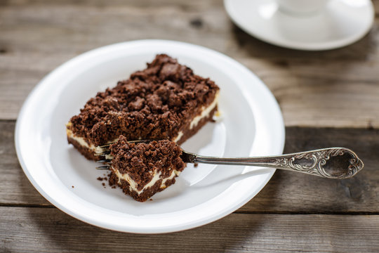 Kaffeegedeck: Zupfkuchen auf wei&szlig;em Teller mit Gabel, Kaffeetasse, Holztisch