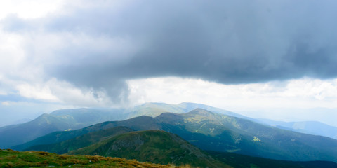 Panoramic view on thunderstorm clouds from Hoverla, Carpathian mountains, Ukraine. Horizontal outdoors shot