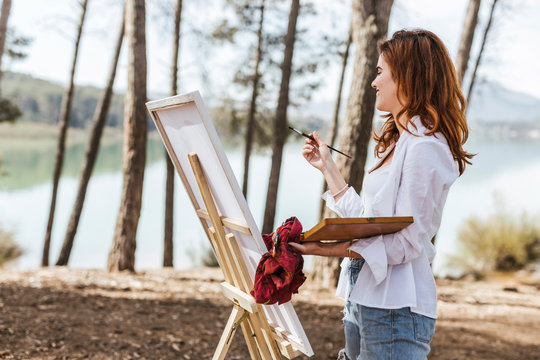 Young woman painting in countryside