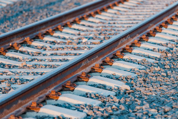 View of the rails, concrete sleepers and mound of crushed stone. The railroad tracks.