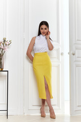 Beautiful sexy woman wear fashion summer collection clothes casual style skirt blouse party office dress code slim body pretty face model pose accessory brunette hair interior room studio makeup.