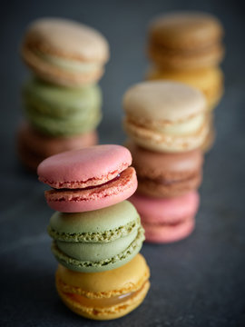 three piles of bright fresh tasty macaron biscuits on grey board