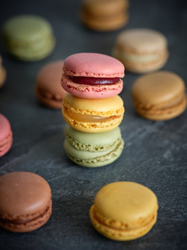 bright fresh tasty macaron biscuits on grey board and dry fruits