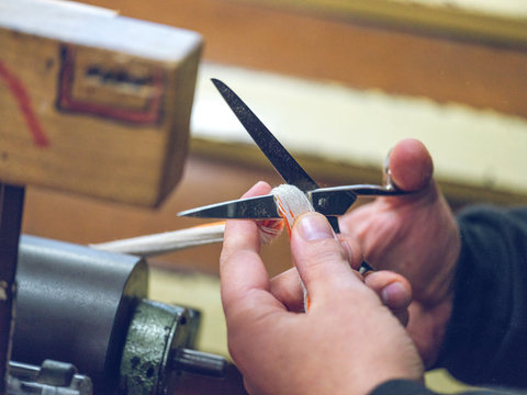 Crop person cutting threads on loom