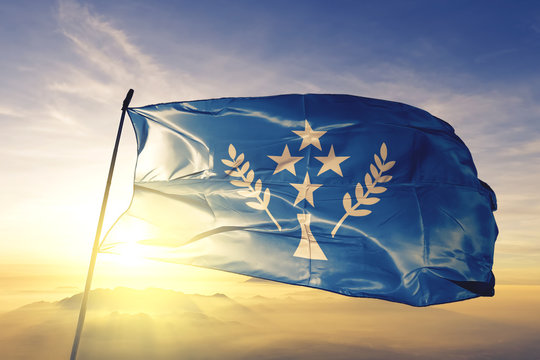 Kosrae state of Micronesia flag waving on the top sunrise mist fog