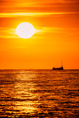 Bright sunset with large yellow sun overr the sea surface in Santa Suzanna, Spain