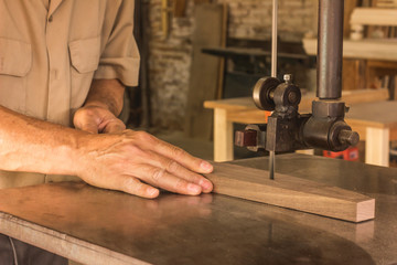 carpenter cutting plank with saw