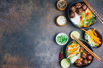 Meatballs with teriyaki souce, rice noodle, vegetables and sesame seeds