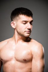 Fototapeta premium Lifestyle closeup portrait of attractive handsome shirtless young man posing in photo studio