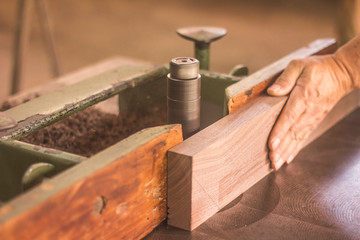 carpenter cutting plank with saw