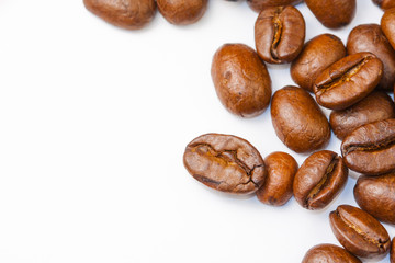 Freshly ground coffee beans roasted with fruits of coffee plant, on white background.