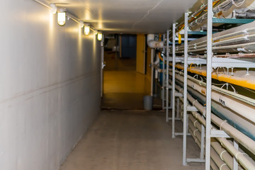 a well lit Maintainance Hallway in an industrial building with conduit running down the side.