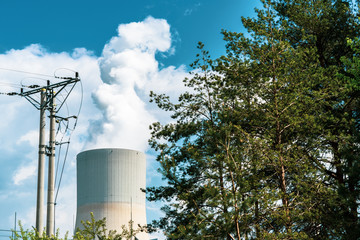 Cooling towers of nuclear power plant. Visible power line and part of forest