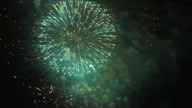 Fireworks or salut. Multi Colored explosions and smoke in night sky. Symbol of holiday celebration. Footage with copy space from right