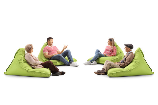 Young And Senior People Sitting On Bean Bag Chairs And Talking