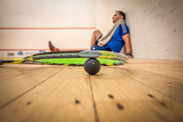 A man resting against the side wall after a very hard game of squash