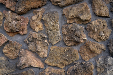 Close-up surface of the old dirty fence made of natural stone and cement