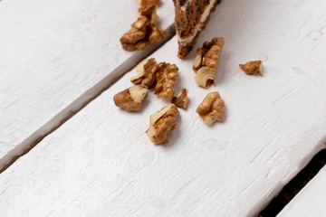 carrot cake with walnuts on a white wood background. selective focus