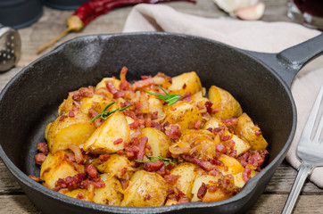 Tyrolean fried potatoes with bacon and onion in a pan. Tyrolean potato specialty