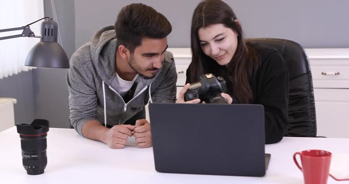 Young Professional Female Photographer and Her Male Model choosing picture from digital camera