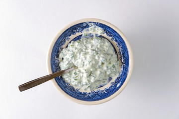 dinner sauce: sour cream and onions in a bright porcelain plate on white