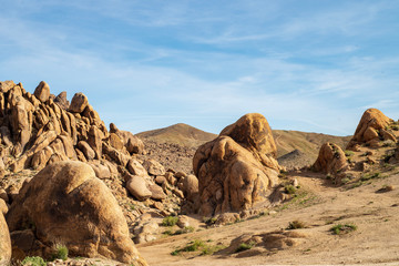 distant dirt road up hill rock formations foreground in Alabama Hills Sierra Nevada California