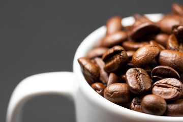 Freshly ground roasted coffee beans with fruits of coffee plant, full of grains.