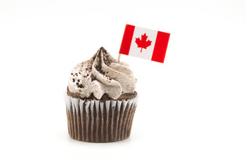 cookies and cream frosted cupcake with a Canadian maple leaf flag toothpick isolated on white