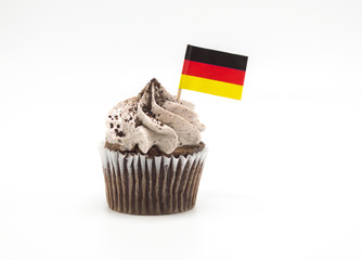 cookies and cream frosted cupcake with a red, gold and black German flag toothpick isolated on white