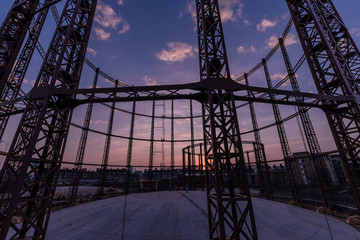 Silhouette of empty gas storage cylinders against the dusk sunset sky in London.
