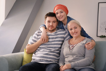 Family visiting young woman with cancer indoors