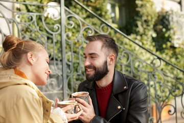 Lovely young couple enjoying tasty coffee outdoors