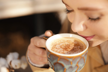 Young woman enjoying tasty coffee outdoors, closeup
