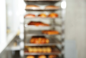 Blurred view of rack with pastries in bakery workshop