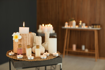 Beautiful composition with candles and spa accessories on table in salon. Space for text