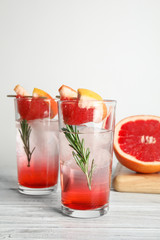 Glasses of cocktail and grapefruit half on table. Space for text