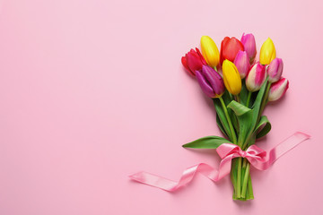 Beautiful bouquet of spring tulip flowers on color background, top view. Space for text