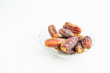 Close up, dates on glass tray isolated on white background, selective focus, Islam religion fasting on ramadan mubarak celebration concept.