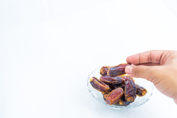 Close up, dates on glass tray isolated on white background, selective focus, Islam religion fasting on ramadan mubarak celebration concept.
