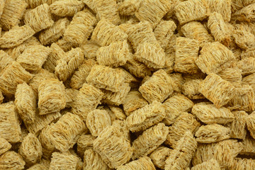 Background from close up of dry shredded whole wheat cereal squares 