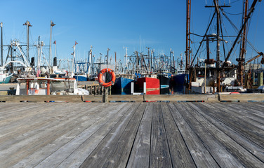Bright orange life buoy on dock at commercial fishing harbor dock