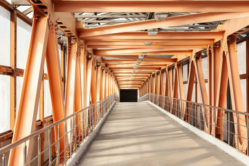Orange Metal Construction Of Pedestrian Overpass. Pedestrian Bridge Constructed From Heavy Metal Beams And Channels.