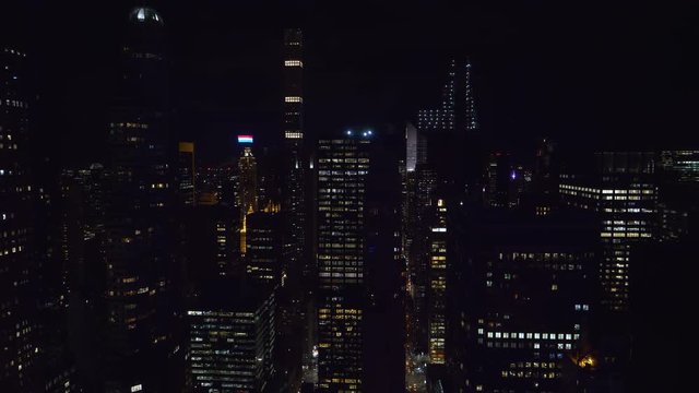 CLOSE UP: Spectacular view of countless skyscrapers of New York lit up at night. Picturesque view from above of glassy high rise office buildings in a bustling metropolitan city in the night-time.