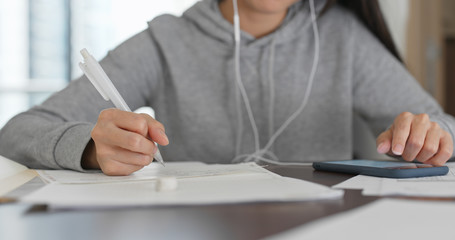 Woman study on paper note with cellphone at home