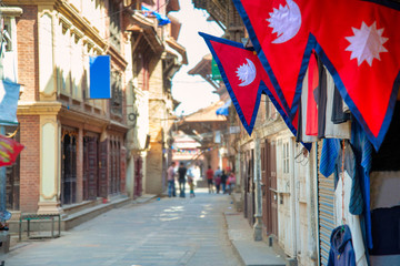 The Nepal national flag in foreground decoration in front of nepali house and the background is perspective of village in Kathmandu Nepal.