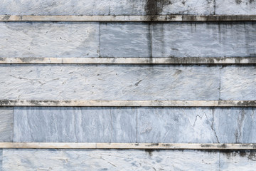 Old weathered blue gray stone wall with lichen with horizontal lines, as a textured background