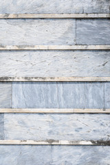 Old weathered blue gray stone wall with lichen with horizontal lines, as a textured background