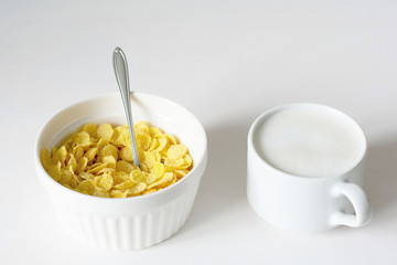 Healthy breakfast with cornflakes and milk over white background